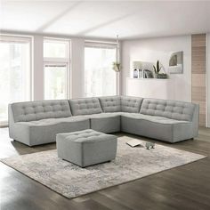 a living room with a large sectional couch and ottoman in it's center area