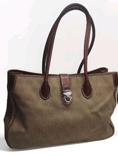 This Dooney & Bourke XL Handbag is a stylish accessory for any woman. The signature leather canvas logo satchel shoulder bag is perfect for travel, casual outings, workwear, or business meetings. The bag features a push lock closure, double handles, and a brown leather handle drop of 8.5 inches. It is the extra large version of the crossbody bag. The exterior is in excellent condition with some flaws that are pointed out in the photos. The bag is made of a jacquard fabric type with a light brown exterior color and silver hardware color. It has a rectangular shape with a width of 16 inches, height of 10 inches, and depth of 6 inches. The bag is lined with pink fabric and features inner pockets, inner dividers, an organizer, and a mobile phone pocket. There are various marks on the lining bu Jacquard Fabric, Pink Fabric, Stylish Accessories, Dooney Bourke, Leather Handle, Purses And Handbags, Light Brown, Bags Handbags, Brown Leather