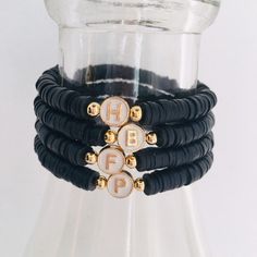 This cute initial bracelet is made with 6mm black vinyl heishi beads and accented with a creamy white enamel initial bead and gold plated spacer beads.  Letters A thru Z available.    It is strung on high quality elastic cord and will be made in an average 7 inch size that will fit most wrists.  If unsure about sizing, measure your wrist and add 1/2 inch to the measurement to determine the size you need.  If a size other than 7 inch is needed, please leave the size in the notes section at checko Beads Letters, Black Polymer Clay, Polymer Clay Bracelet, Custom Bracelet, Clay Bracelet, Letter Bracelet, Personalized Bracelet, Initial Bracelet, Bracelet Black