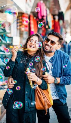 a man and woman standing next to each other with soap bubbles in front of them