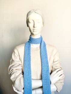 a white mannequin wearing a blue scarf