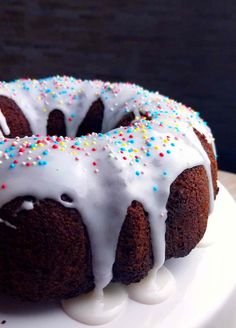 a bundt cake with white icing and sprinkles on a plate