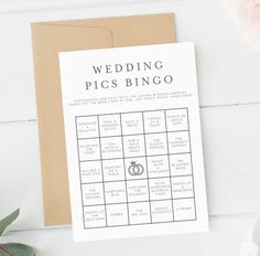 a card with a wedding pics bingo on it next to some flowers and a brown envelope