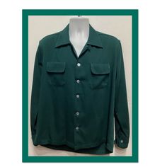 "1950s vintage reproduction dark green Gabardine Shirt with top stitching by Hollywood Rogue This classic 1950's reproduction gabardine shirt is a dark green and has a pointed loop collar, two rounded flap pockets,  five button down front and long sleeves with double button cuffs. The shirt features contrasting white hand finished top stitching on collar and pockets.  This shirt as with all clothing made by \"Hollywood Rogue\" was made to look exactly like an original 1950s garment. The label reads \"Hollywood Rogue\" and the shirt is in new unworn condition. Made in the USA. Please see measurements below as these shirts tend to run large. Size Small MEASUREMENTS: (All measurements were taken lying flat) Shoulders - 18.5\" (measured on back of the shirt from seam to seam) 20\" (measured fr Retro Solid Color Shirt With Button Closure, Classic Green Johnny Collar Tops, Retro Solid Shirt With Button Closure, Fitted Green Shirt With Camp Collar, Retro Green Button-up Shirt, Classic Green Top With Camp Collar, Green Collared Shirt With Snap Buttons, Vintage Green Fitted Shirt, Vintage Fitted Green Shirt