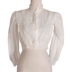 Cutesy white blouse with eyelet pattern at sleeve cuffs, hem, and down the torso. Material is sheer and light.  Measurements Bust: 36" Waist: 28" Length: 14.5" Shoulder-to-Shoulder: 13" Sleeve Length: 22" Condition: Good; some stains (See images) This has not been stain treated by us. Daywear Long Sleeve Blouse With Sheer Sleeves, Long Sleeve Blouse With Sheer Sleeves For Daywear, White Lace Top With Lace Sleeves For Daywear, Feminine Sheer Sleeves Top For Daywear, White Formal Tops With Sheer Sleeves, White Formal Top With Sheer Sleeves, White Sheer Sleeves Top For Formal Occasions, Formal White Tops With Sheer Sleeves, Classic Fitted Blouse With Sheer Sleeves