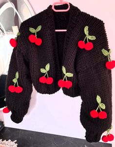 a black sweater with cherries on it