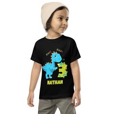 Welcome his next birthday in style customized to reflect his interest.  Cool customized tee for your little ones.  Let your toddler do their thing while feeling super comfy and looking extra stylish in this short-sleeve jersey t-shirt from 100% cotton with a unique print. The tee is soft, durable, and bound to become the staple of your toddler's wardrobe.  * 100% combed and ring-spun cotton * Fabric weight: 4.2 oz/yd² (142 g/m²) * Relaxed fit for extra comfort * Side-seamed construction * Pre-shrunk fabric * Blank product sourced from the US or Honduras This product is made especially for you as soon as you place an order, which is why it takes us a bit longer to deliver it to you. Making products on demand instead of in bulk helps reduce overproduction, so thank you for making thoughtful Birthday Dinosaur Print Short Sleeve T-shirt, Birthday T-shirt With Dinosaur Print, Dinosaur Print Short Sleeve T-shirt For Birthday, First Birthday T-shirt With Dinosaur Print, Dinosaur Print Short Sleeve T-shirt For First Birthday, Crew Neck T-shirt With Dinosaur Print For First Birthday, Birthday Boy Shirt, Dinosaur Outfit, Outfit Birthday