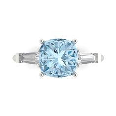 a blue diamond ring with two baguets on the sides and an oval cut center stone