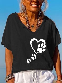 an older woman wearing sunglasses and a t - shirt with paw prints