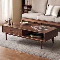 a living room with a couch, coffee table and bookshelf on the floor