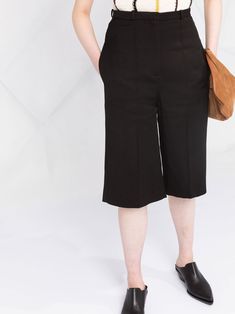 Black silk blend cropped tailored trousers from TOTEME featuring tonal design, front button and zip fastening, belt loops, two side slit pockets, straight leg, cropped leg and pressed crease. Conscious: We've partnered with Good On You – an ethical agency that rates how sustainably brands perform. This item comes from a brand that performs well in relation to their impact on people, which ensures good working conditions in the supply chain.. | Totême Cropped Tailored Trousers Suit Shorts, Leg Press, Tailored Trousers, Supply Chain, Black Silk, Straight Leg, Trousers, Silk, Brand New