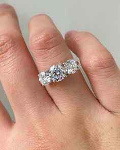 three stone diamond ring on hand with white background