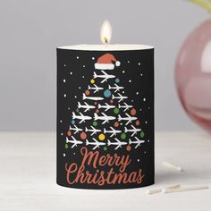 a candle with an airplane christmas tree on it