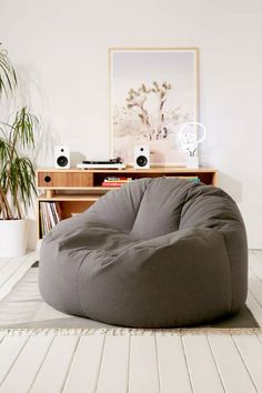 a large bean bag chair sitting on top of a wooden floor next to a potted plant