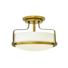 a semi flush ceiling light with a white glass shade on the bottom and gold trim