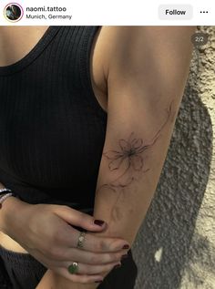 a woman's arm with a spider tattoo on it