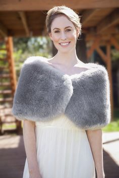 a woman wearing a white dress and fur shawl