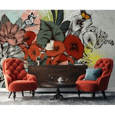 two chairs and a table in front of a wall with colorful flowers on it,