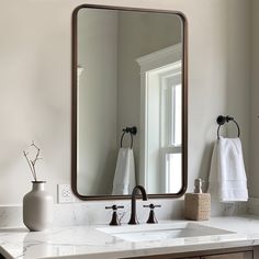 a bathroom sink sitting under a large mirror