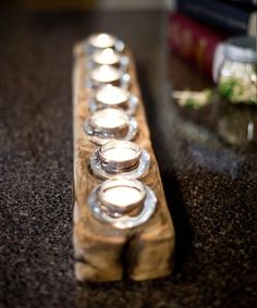 a row of candles sitting on top of a wooden block