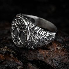 This stunning signet style stainless steel ring features a Tree of Life design on the top and dramatic bear paws on the shoulders. This ring makes for an excellent piece of jewelry that can be worn by anyone. The Tree of Life is symbolic of life, growth, strength, and knowledge. The Bear Paw is reflective of wisdom, intelligence, stability, and creativity. Wear this ring to represent your own personal journey through life! Adjustable Stainless Steel Engraved Ring, Adjustable Engraved Stainless Steel Rings, Engraved Stainless Steel Signet Ring For Anniversary, Symbolic Stainless Steel Engraved Ring For Anniversary, Engraved Stainless Steel Signet Ring For Promise, Symbolic Stainless Steel Engraved Signet Ring, Vintage Stainless Steel Signet Ring For Anniversary, Sturdy Stainless Steel Jewelry For Gifts, Sturdy Stainless Steel Jewelry As A Gift