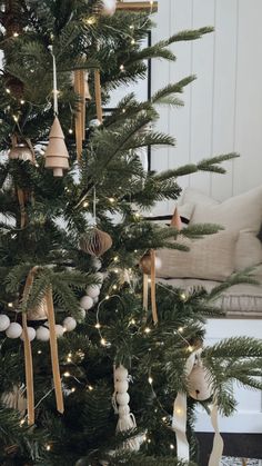 the christmas tree is decorated with gold and white ribbons, ornaments, and other decorations