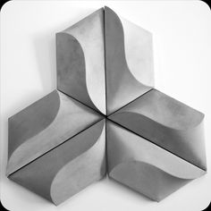 an abstract sculpture made out of concrete blocks on a white surface with black and white lines