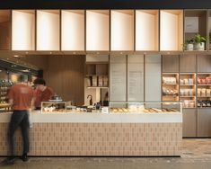 a man standing in front of a bakery counter