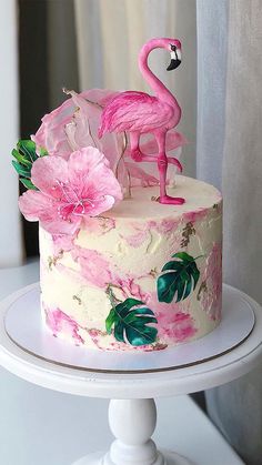 a pink flamingo cake sitting on top of a white table