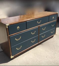 a blue dresser with gold handles on it's drawers is shown in this image