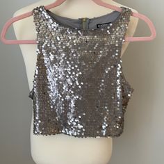 Brand New. Gorgeous Silver Sequence Cropped Top With Zipper Enclosure In The Back. Can Be Worn With Jeans To Dress Up For A Night Out Or Also For A Dressy Event. 100% Polyester Trendy Sleeveless Sequined Crop Top, Trendy Sleeveless Crop Top With Sequins, Chic Sleeveless Sequined Crop Top, Burgundy Lace Top, Sequence Top, Ruffle Top Blouses, Cutout Crop Top, White Knit Top, Top With Zipper