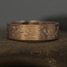 a wedding band with leaves engraved on it