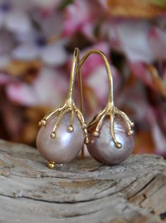 Large Pink Pearl Earrings are a striking blend of natural beauty and contemporary elegance. These Large pink pearl earrings, featuring rare, large pink pearls, are an epitome of sophistication, designed to add a touch of glamour to your ensemble. Pearl Quality: Each earring showcases a very large, near round gold pink freshwater pearl, renowned for its rarity and luminous sheen, making these Large pink pearl earrings truly unique. Metal: The pearls are gracefully suspended from high-quality silver that is gold plated, offering a luxurious look with lasting shine. Design: Inspired by the wonders of nature, these earrings embody a minimalist yet bold style. The large pink pearls make a statement, while the design retains an air of elegant simplicity. Size: The huge pearls ensure these earrin Elegant Pink Teardrop Pearl Earrings, Elegant Pink Pear-shaped Earrings, Elegant Handmade Pink Gold Earrings, Large Pearl Necklace, Large Bead Necklace, Pink Pearl Earrings, Large Pearl Earrings, Grey Pearl Necklace, Pearl Statement Earrings