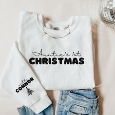 a white shirt that says antter's 1st christmas next to some denim shorts