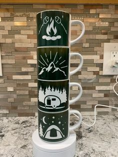 a stack of coffee mugs sitting on top of a counter next to a wall