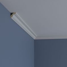 the corner of a room with blue walls and a light fixture on the ceiling above it