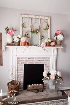 a living room with a fire place and flowers on the mantle