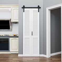 an open white door in a kitchen next to a wall mounted flat screen tv on the wall