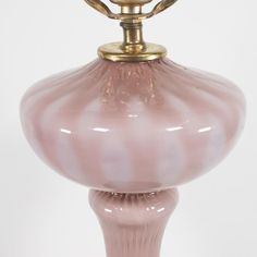 a pink glass vase with a gold top