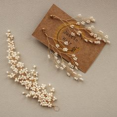 a card with some pearls on it next to a pair of earrings and a string of beads