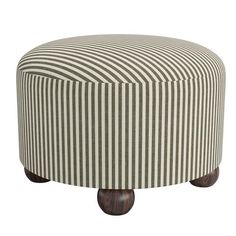 a round ottoman with wooden legs and striped upholstered fabric on the top,