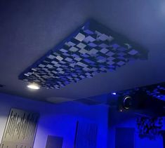 a room that has some lights on the ceiling and blue lighting in the ceiling above it