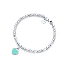 Inspired by the iconic key ring first introduced in 1969, the Return to Tiffany collection is a classic reinvented. An elegant bead bracelet and engraved tag combine to create a simple and timeless design. Sterling silver with Tiffany Blue® enamel finish; Size extra small; Fits wrists up to 5.25"; Beads, 4 mm; Instantly recognizable, the signature Tiffany Blue® hue of this design’s enamel finish has been as iconic as the brand itself since its founding in 1837 | Return to Tiffany® Tiffany Blue® Tiffany Bead Bracelet, Tiffany And Co Bracelet, Tiffany And Co Jewelry, Tiffany Bracelets, Return To Tiffany, Azul Tiffany, Heart Tag, Tiffany Jewelry, Silver Bead Bracelet