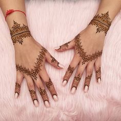 two hands with henna tattoos on them