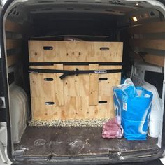 the back end of a white van with wooden crates