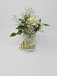 a vase filled with white flowers and baby's breath