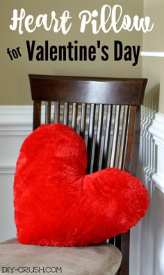 a red heart pillow sitting on top of a chair in front of a wall with the words, heart pillow for valentine's day