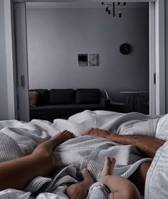 a man laying on top of a bed next to a baby