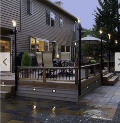 an outdoor patio with lights on the side of it and steps leading up to the back door