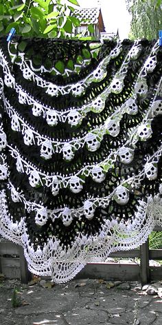 there is a black and white crocheted shawl with skulls hanging from it